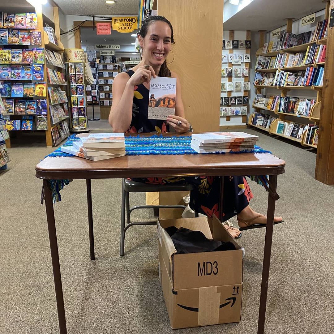 Toby Israel signing her book at a book signing. Vagabondess, Vagabunda. Female author.