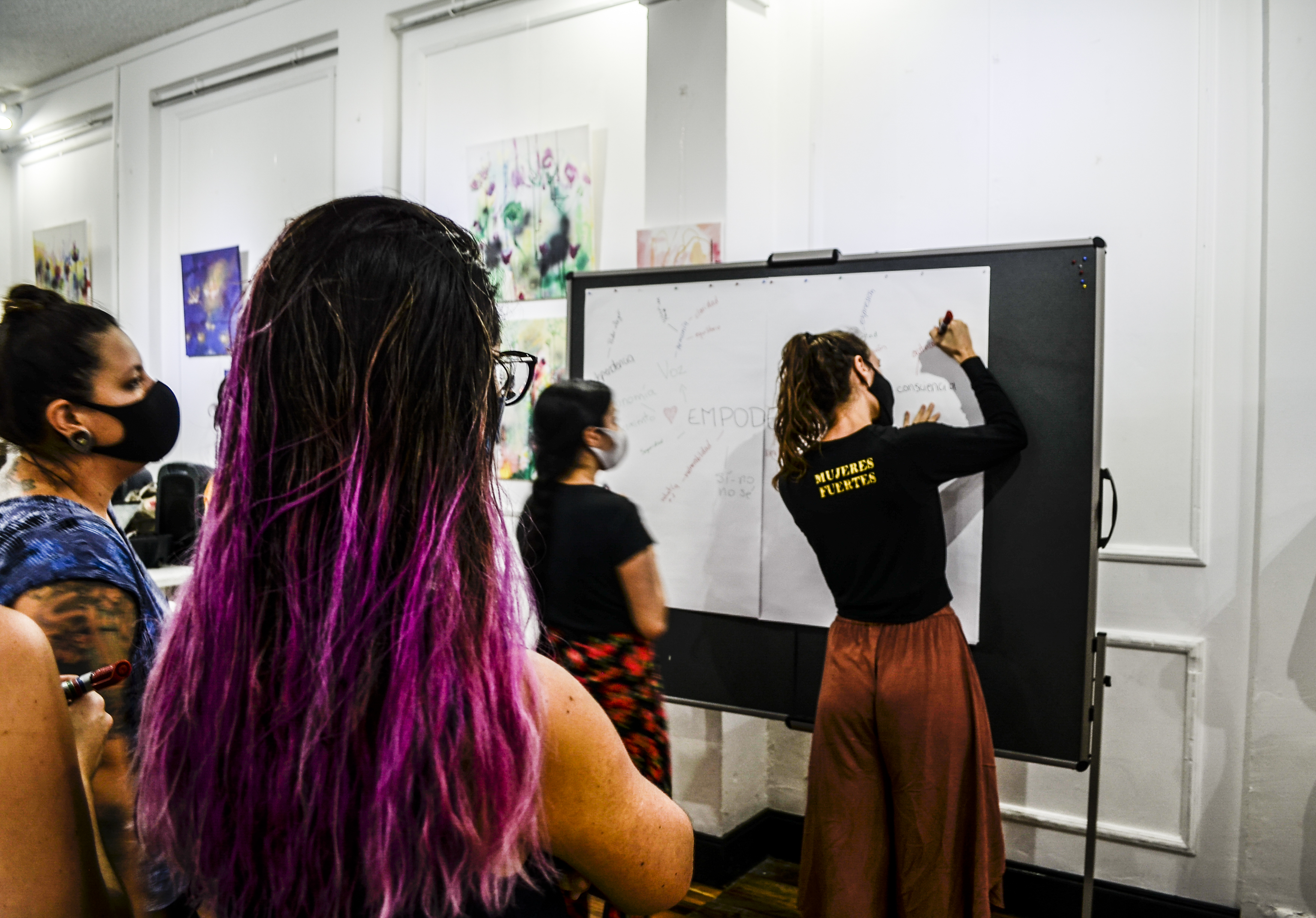 Toby Israel teaches at the whiteboard during a Mujeres Fuertes empowerment workshop
